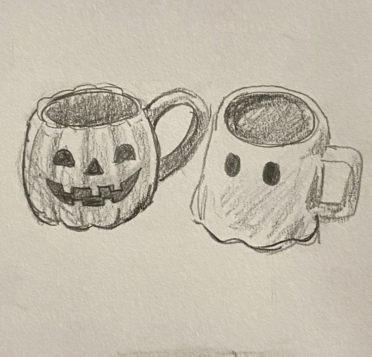 two pumpkin mugs with faces drawn on them