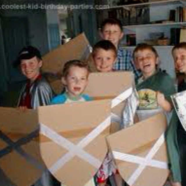 a group of people standing around each other holding cardboard boxes