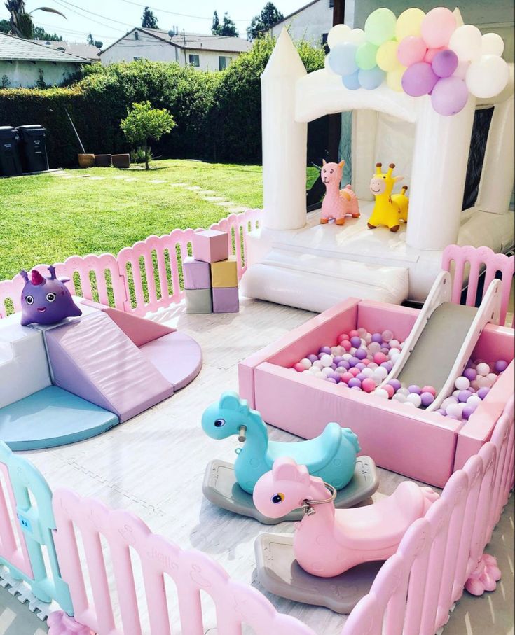 an inflatable pool is set up for a birthday party with balloons and toys