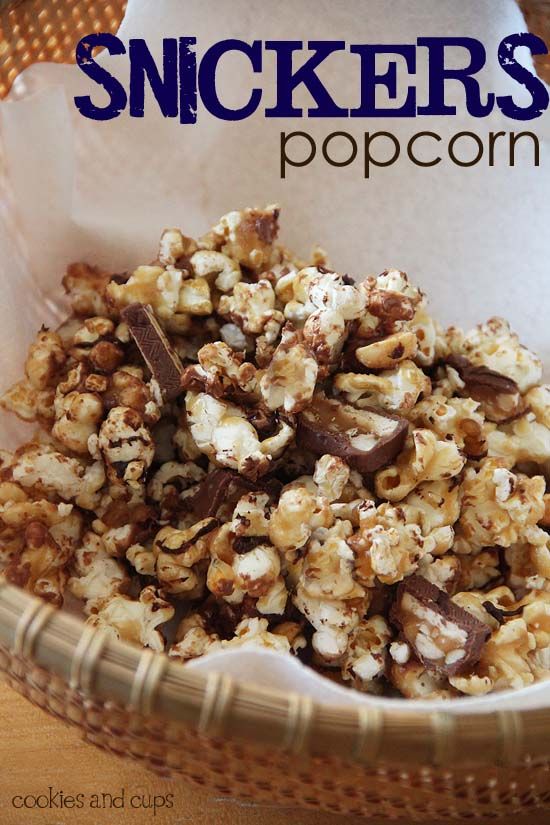 a bowl filled with chocolate covered popcorn on top of a wooden table