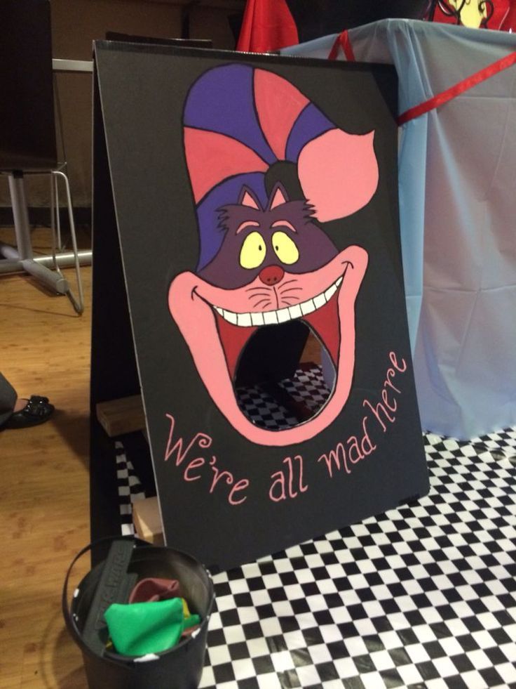 there is a sign that says we're all mad here with an evil mouse on it