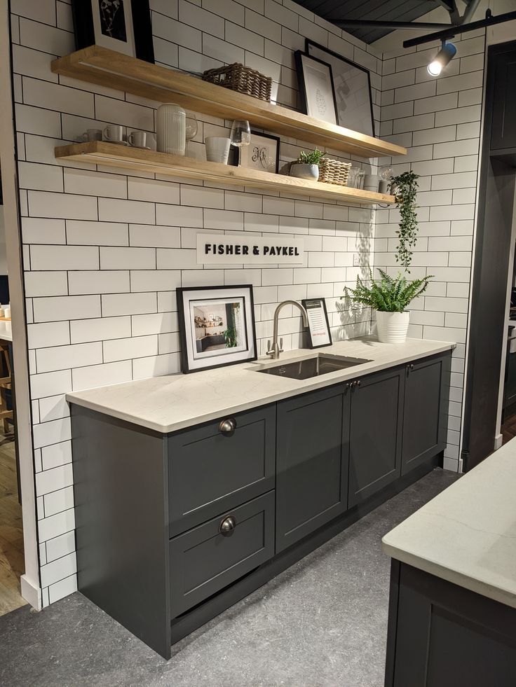 a kitchen with white brick walls and gray cabinets