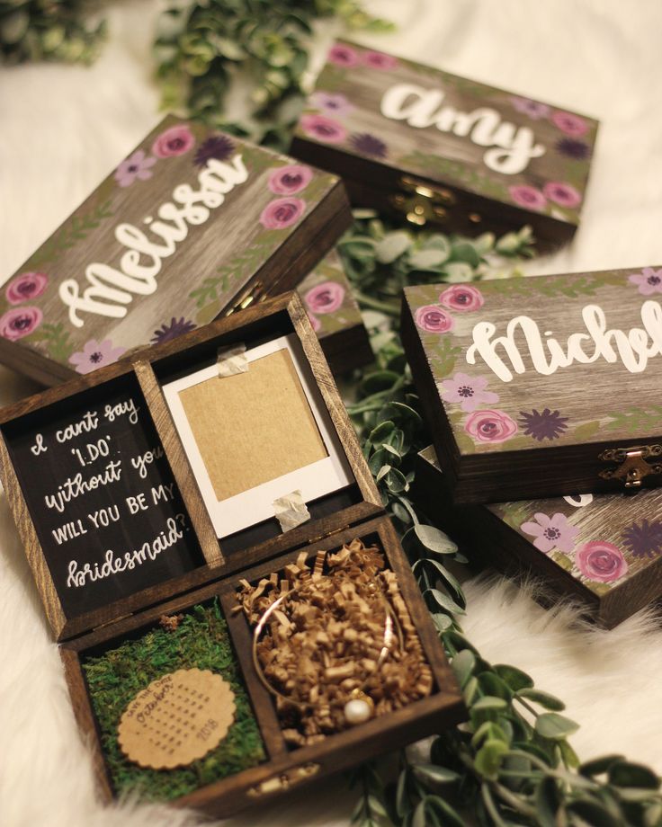 four wooden boxes with flowers and words on them sitting on a white furnishing