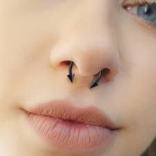 a woman's nose with an arrow piercing on it