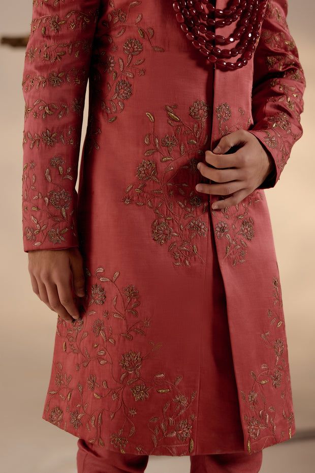 Red Ochre Sherwani Set | Jatin Malik Introducing our stunning red ochre hand-embroidered sherwani, adorned with exquisite tone-on-tone resham work, intricate gold zari, and dabka details, embodying timeless elegance and sophistication. Paired with an ombre hand-embroidered stole and a tone-on-tone safa, this ensemble exudes refined charm and impeccable style. Perfect for those seeking to make a statement with their attire, this sherwani set beautifully combines tradition with contemporary flair, making it ideal for special occasions and celebrations. Included in purchase: Sherwani, Kurta, Churidar, Stole, Safa Product Specification Color: Red Fabric: Linen silk Occasion: Engagement, Wedding, Bridal, Reception Style: Sherwani, Kurta, Churidar, Safa, Stole Care: Dry Clean Work: Hand Embroide Red Traditional Wear With Dabka For Reception, Festive Sherwani With Gold Embroidery In Raw Silk, Red Sherwani With Intricate Embroidery For Reception, Red Embroidered Sherwani For Reception, Red Bollywood Style Sherwani In Jamawar, Red Jamawar Sherwani With Resham Embroidery, Red Jamawar Sherwani With Zari Work, Red Jamawar Sherwani For Wedding, Red Dabka Traditional Wear For Ceremonial