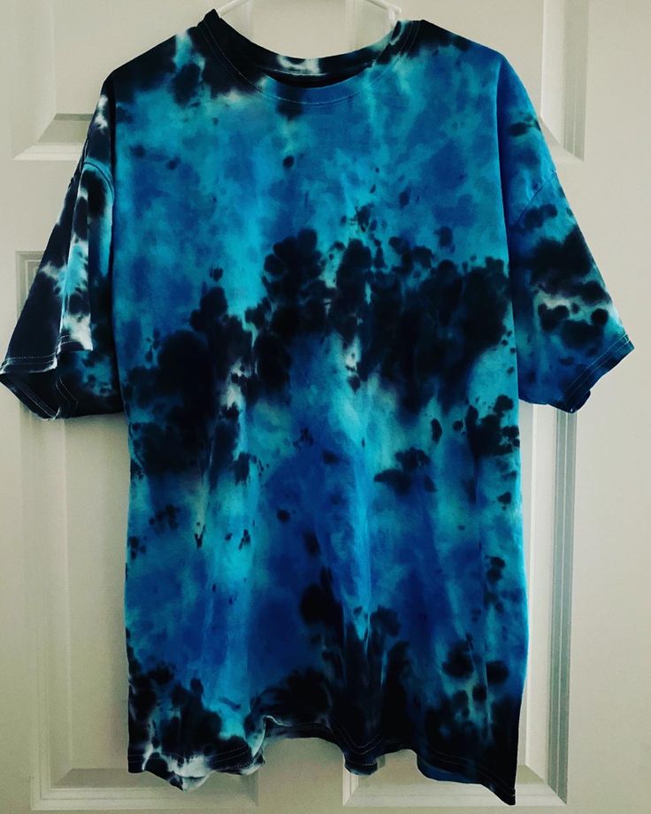 a blue and black tie dye shirt hanging on a door