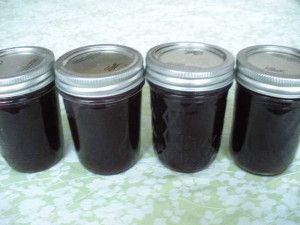 four jars filled with jam sitting on top of a table