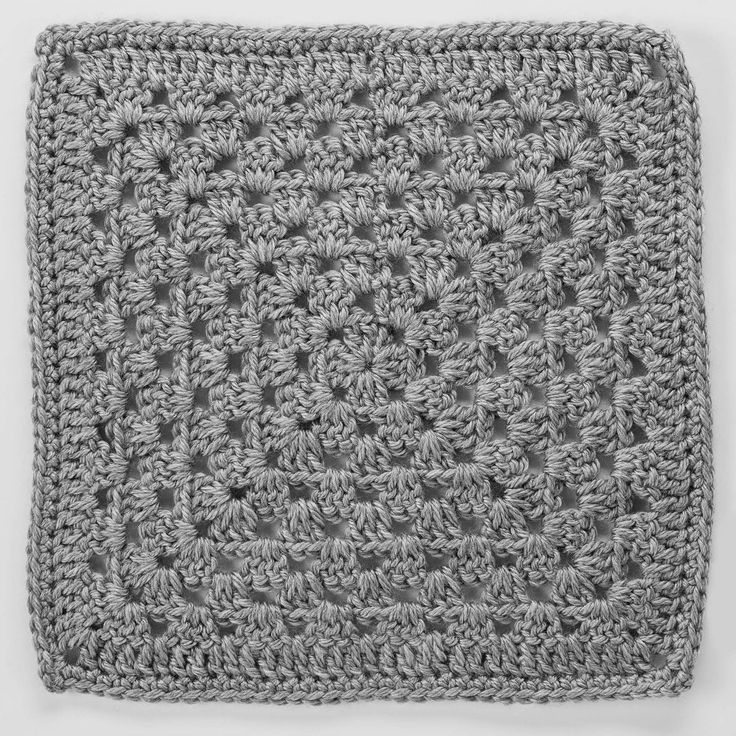 a crocheted square is shown in grey and white