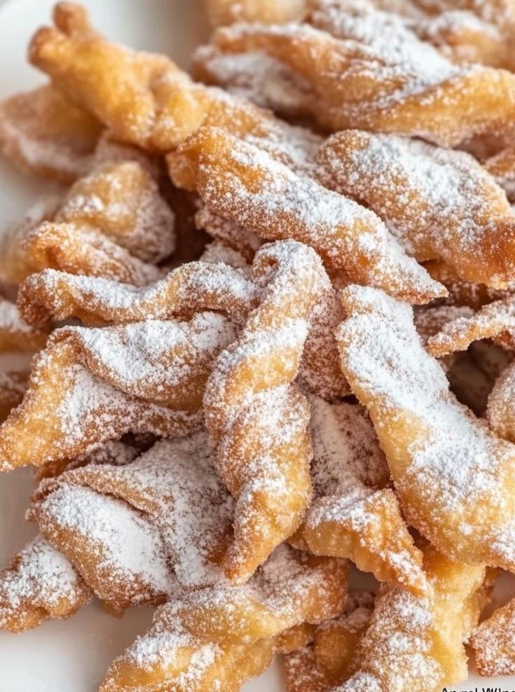 powdered sugar coated donuts on a white plate