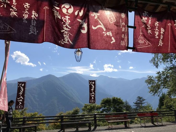 banners hanging from the side of a building with mountains in the background