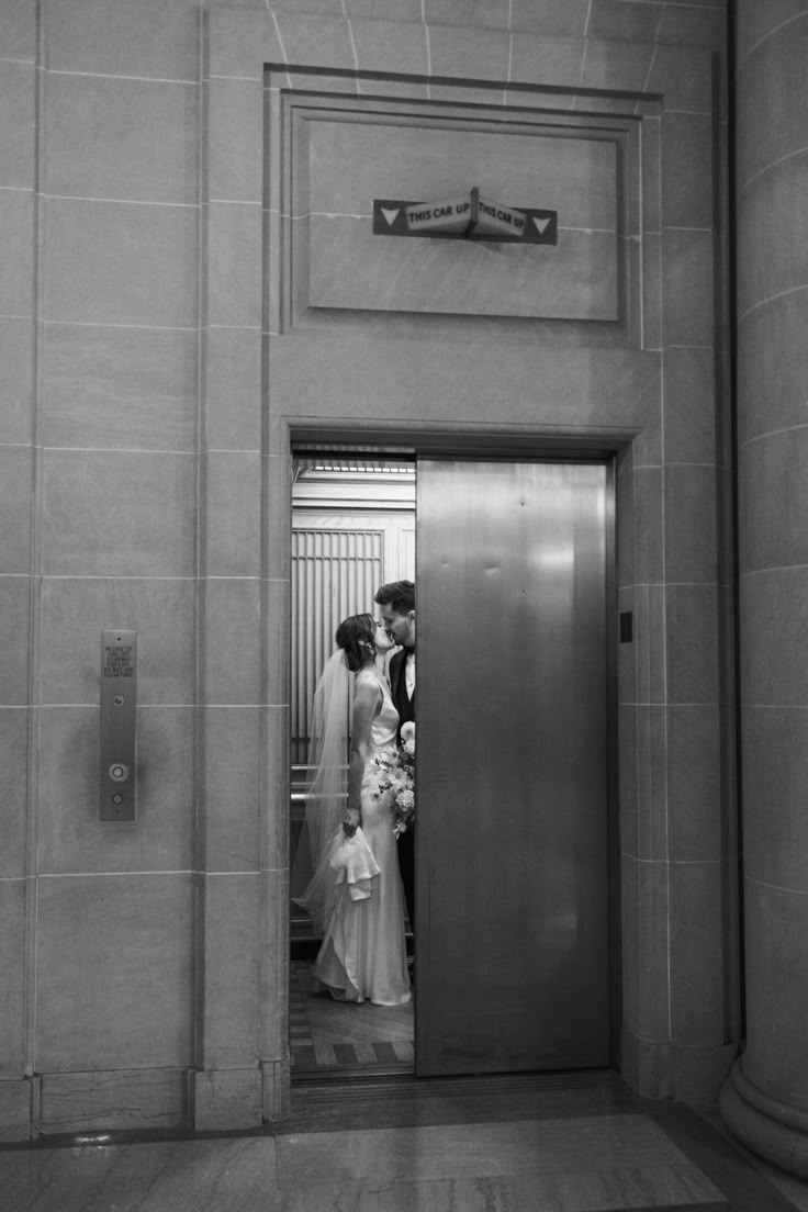 a bride and groom kissing in an elevator