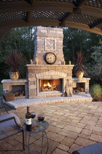 an outdoor fireplace with a clock on it