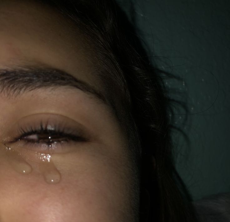 a close up of a person with tears on their eyes