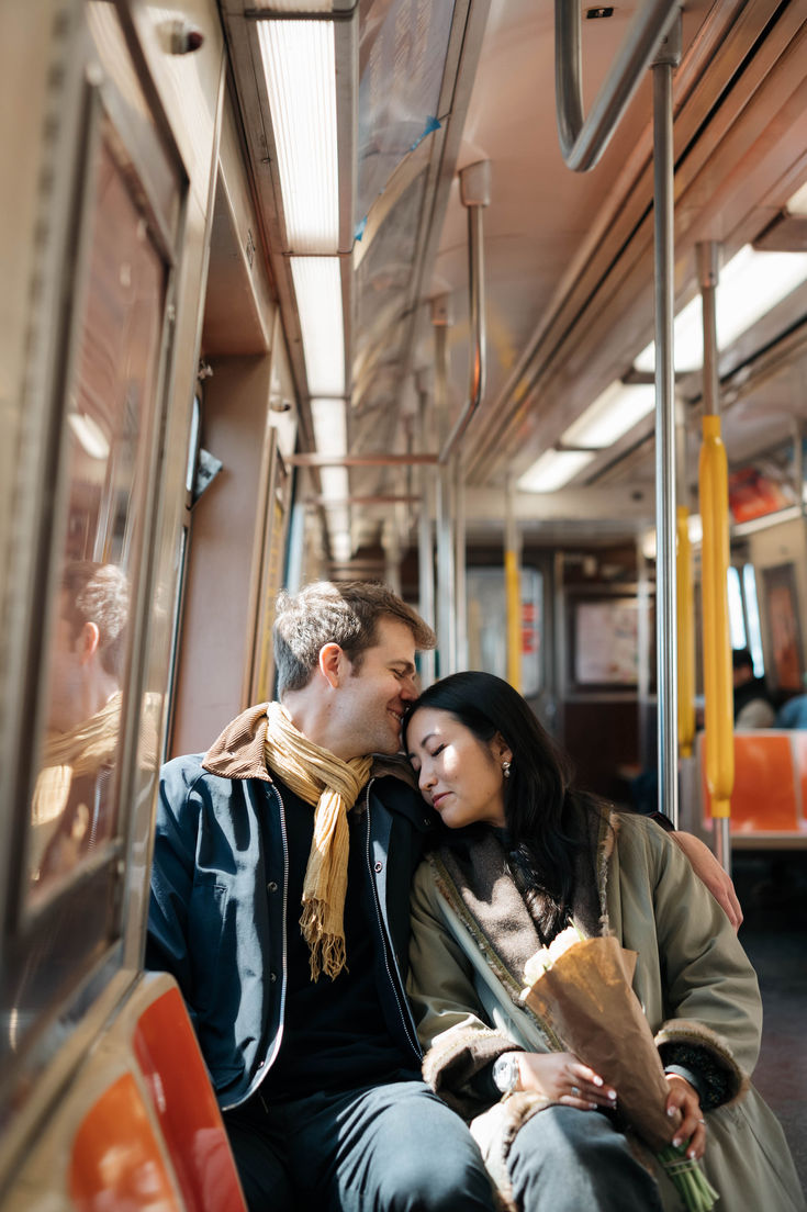 a man and woman sitting on a subway car