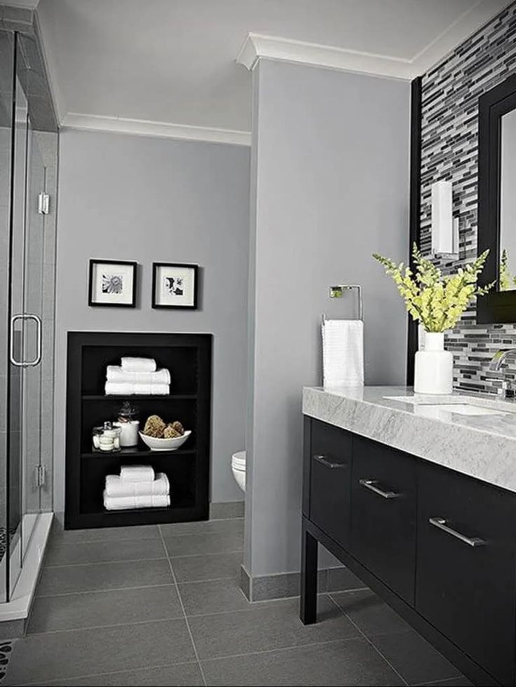 a bathroom with gray walls and white towels on the counter, along with black cabinets