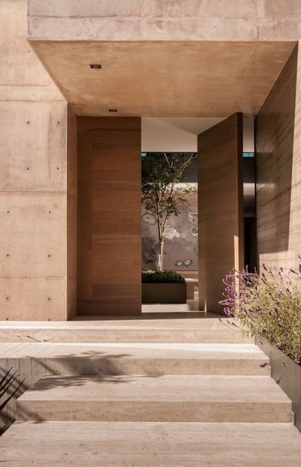 an entrance to a building with concrete steps and planters on either side of it