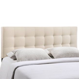 the headboard is made up with white linens and buttons on it's sides