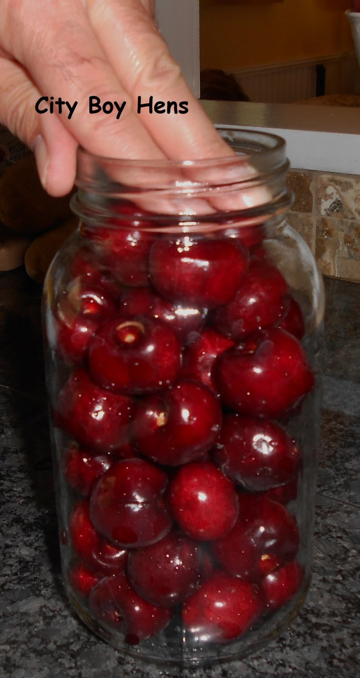 a person picking up cherries from a jar