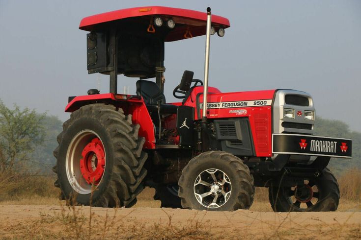 a red tractor parked on top of a dirt road