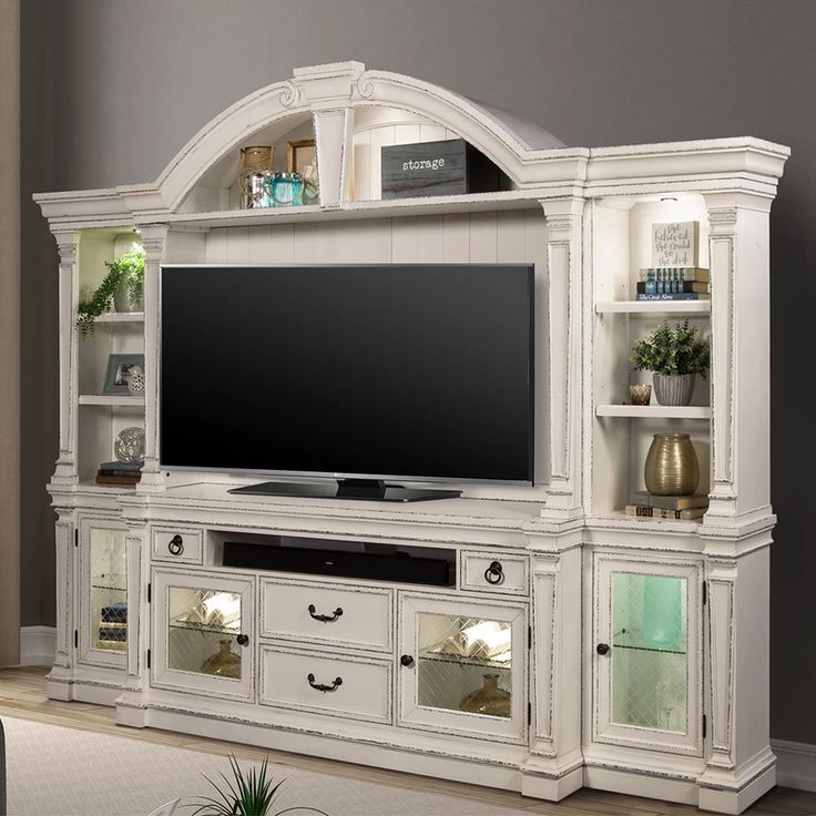 a white entertainment center with shelves and a flat screen tv