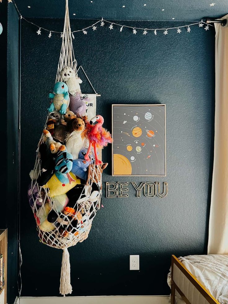 there is a hammock hanging from the wall with stuffed animals and toys on it