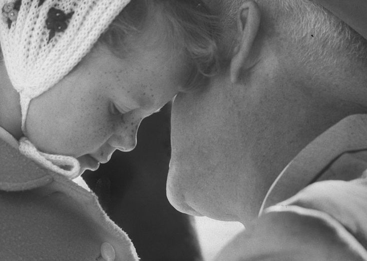 a black and white photo of a woman holding a baby