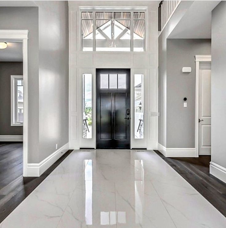 an empty hallway with white walls and wood flooring is seen in this image from the front door