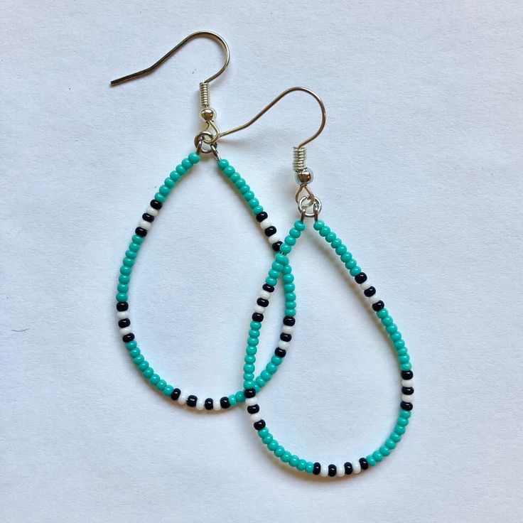 pair of turquoise and black beaded tear earrings on white background with clippings