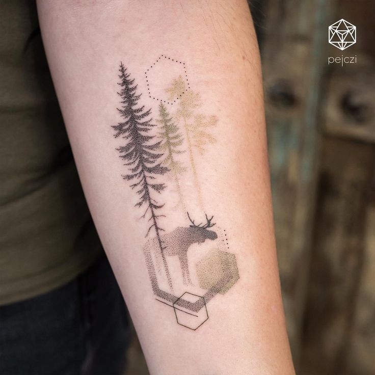 a tattoo on the arm of a woman with trees and an antelope in it