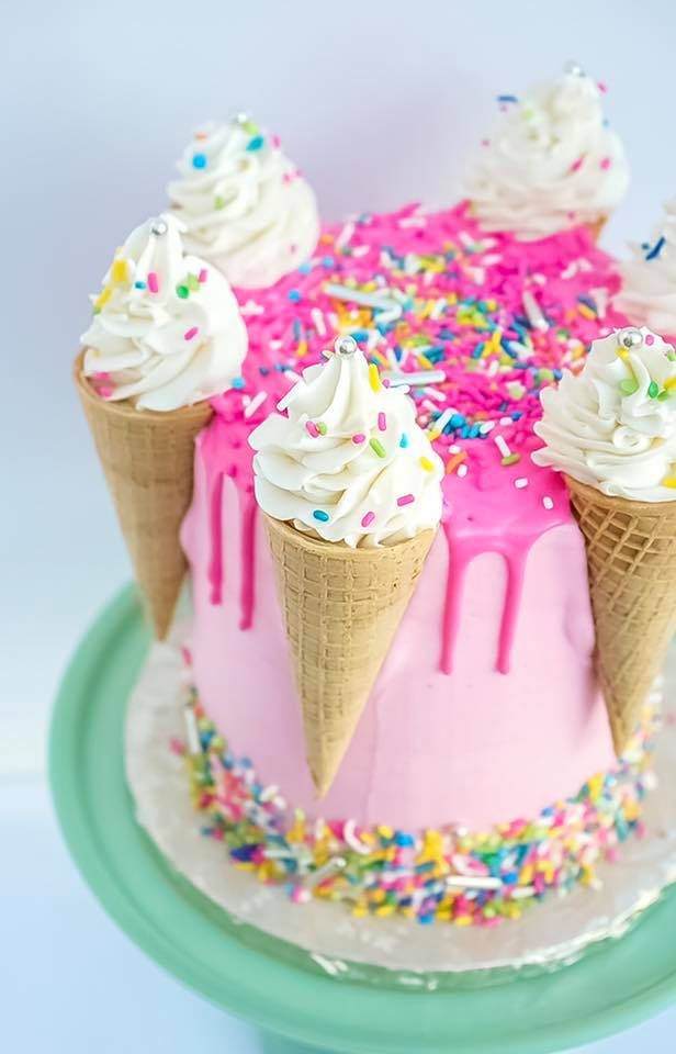 an ice cream cake with sprinkles and icing on a green plate