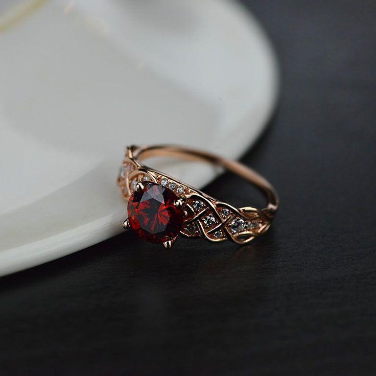 a close up of a ring on a table with a white plate in the background