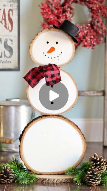 a snowman made out of wood sitting on top of a table next to pine cones