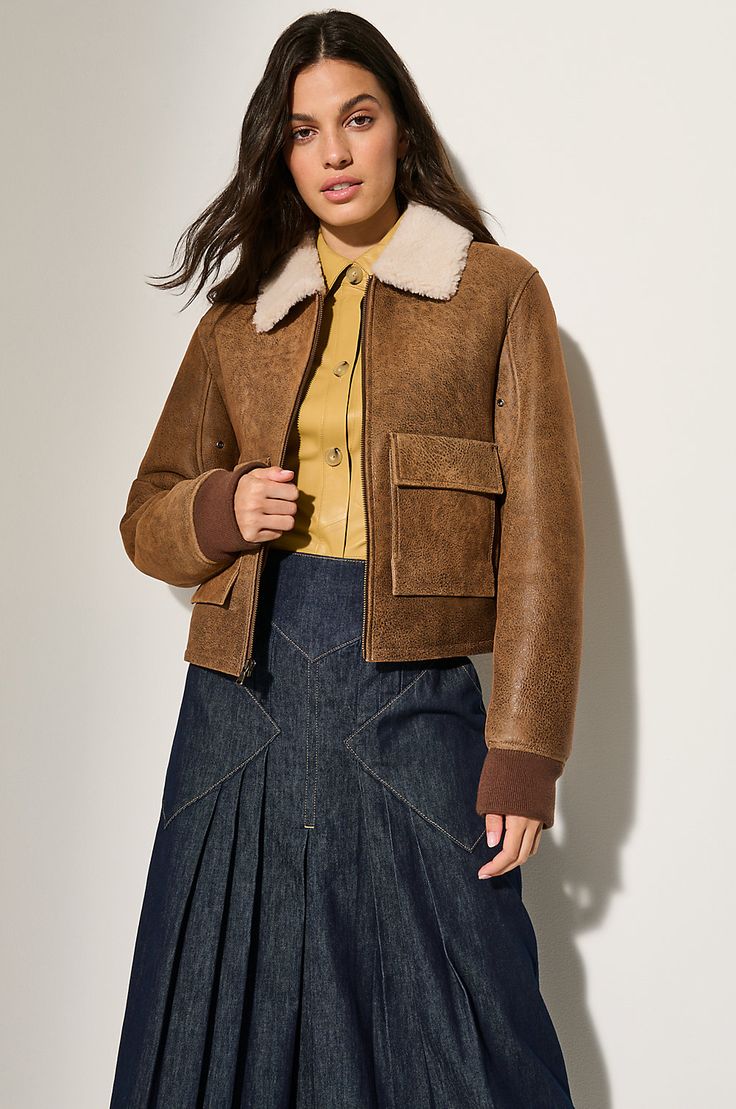 The Kelly sheepskin bomber is a fresh spin on a timeless classic. Its oversized outer pockets not only add dramatic flair, but also offer ample storage space. The fitted, flattering silhouette ensures a stylish appearance, while the rugged design is softened by a contrasting, soft collar that can be popped up to protect the neck from cold temperatures and knit cuffs that help retain warmth close to the body. Classic Winter Cropped Jacket With Flap Pockets, Classic Cropped Jacket With Flap Pockets For Winter, Luxury Outerwear With Pockets For Fall, Shearling Outerwear With Pockets For Work, Fitted Shearling Outerwear For Work, Fitted Sheepskin Outerwear For Fall, Chic Shearling Leather Jacket For Work, Classic Sheepskin Leather Jacket For Work, Casual Shearling Leather Jacket For Fall