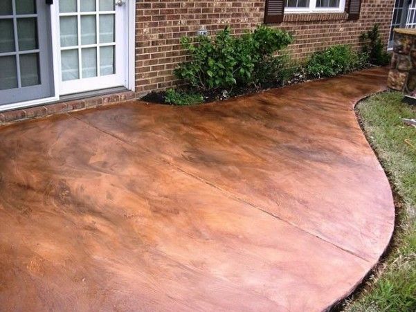 a large concrete patio in front of a brick house