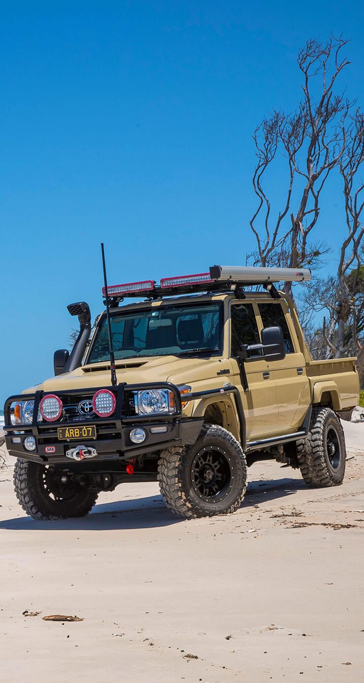 a yellow truck parked on top of a sandy beach