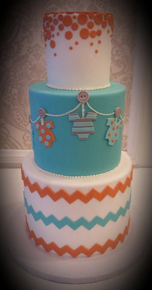 a three tiered cake decorated with clothes and polka dots