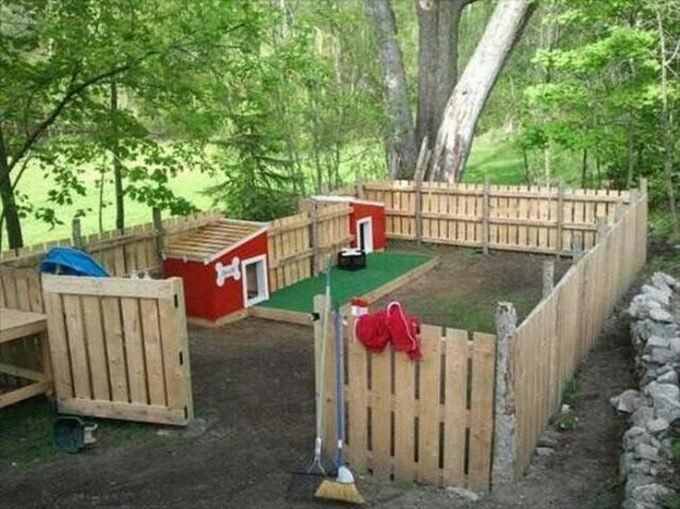 an outdoor play area in the woods with wooden fences and dog houses on each side