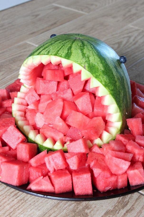 a watermelon and melon cut in half on a plate with other pieces