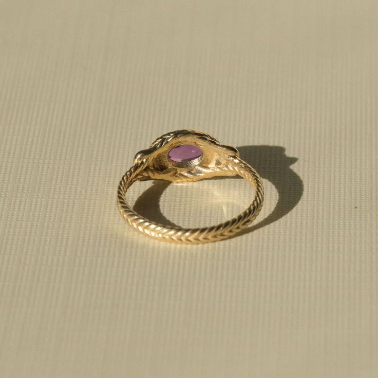 Inspired by ancient rings that graced the hands of Roman Empresses, this is a piece to be treasured for decades and passed down through the centuries. A detailed braided solid gold band encircles your finger, displaying a substantial cabochon amethyst in a handcrafted bezel setting. This setting is the same used by ancient goldsmiths from the earliest known periods of history. The Romans believed amethyst carried within it temperance and grace, a talisman to ward off drunkenness and the regrets Timeless Gold Amethyst Ring, Ceremonial Yellow Gold Emerald Heirloom Ring, Ceremonial Heirloom Yellow Gold Emerald Ring, Heirloom Amethyst Birthstone Ring, Spiritual Birthstone Ring For Formal Occasions, Fine Jewelry Amethyst Gold Ring, Fine Jewelry Gold Amethyst Ring, Fine Jewelry Gold Ring With Amethyst, Antique Hand Forged Rings For Ceremonial Occasions