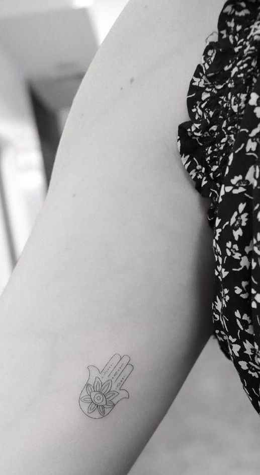 a woman's arm with a small tattoo on the left side of her body