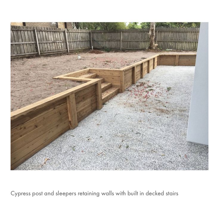 an empty backyard with wooden steps and gravel