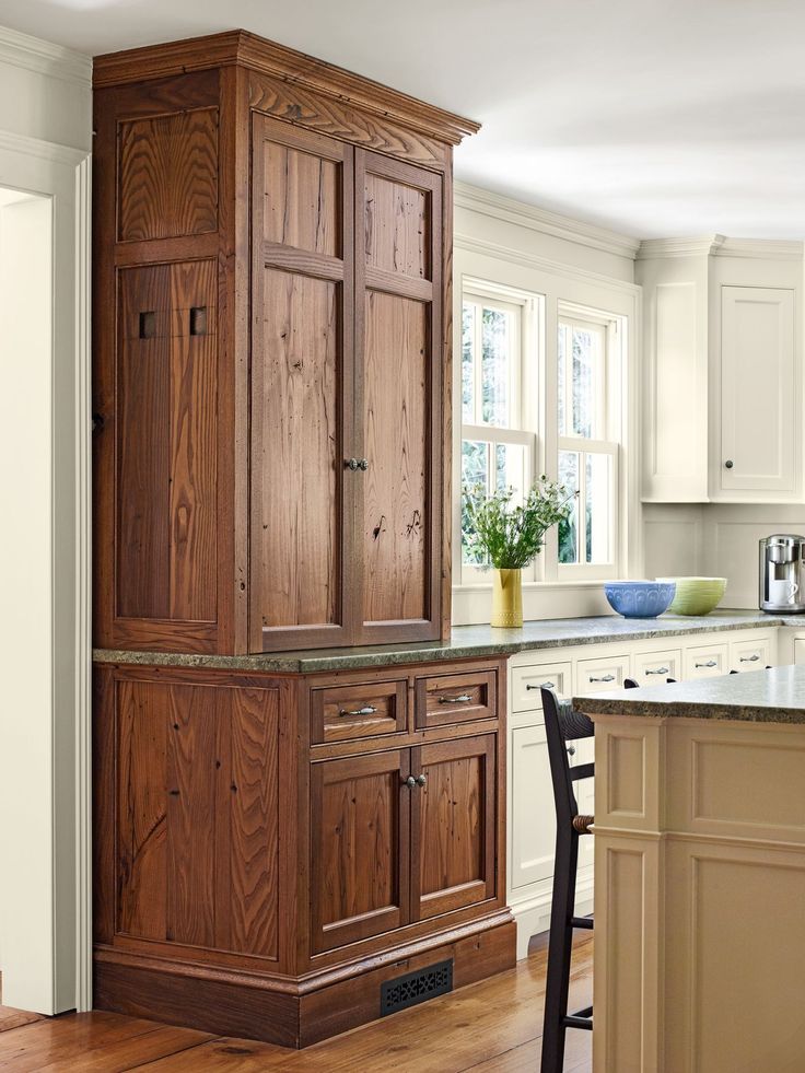 a large wooden cabinet sitting in the middle of a kitchen