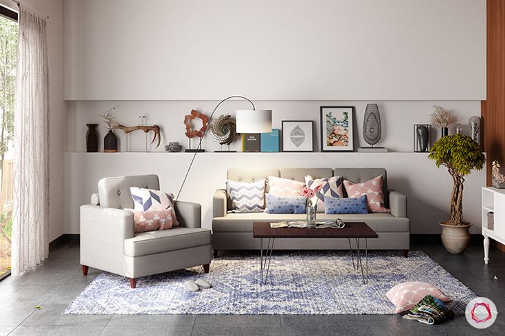 a living room with two couches and pictures on the wall above them, in front of a sliding glass door