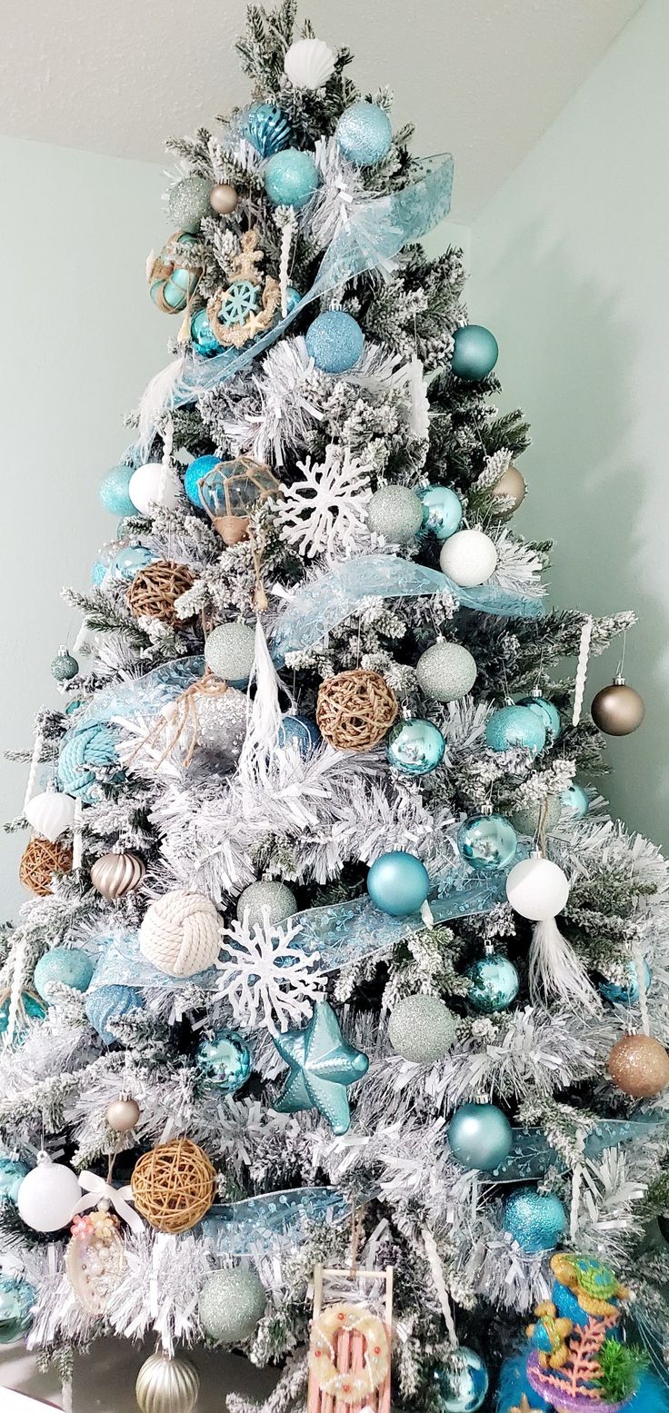 a white christmas tree with blue and silver ornaments