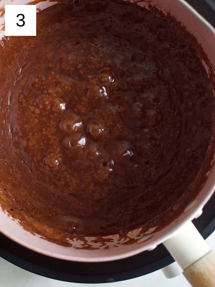 a pan filled with chocolate cake batter on top of a stovetop oven burner