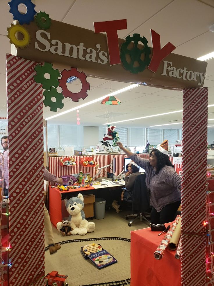 people in an office decorated for christmas with decorations on the ceiling and around the archway