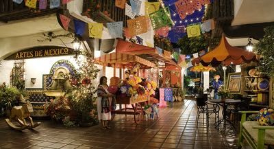 the interior of a mexican restaurant decorated in bright colors and decorations with flags hanging from the ceiling