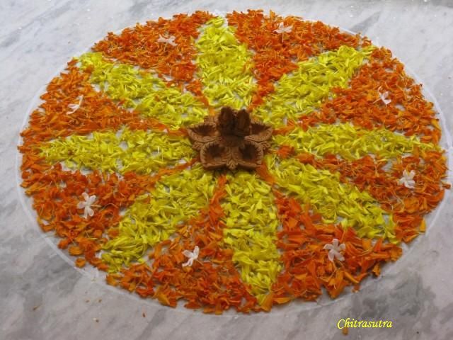 an orange, yellow and white flower arrangement on a marble table with the center surrounded by petals