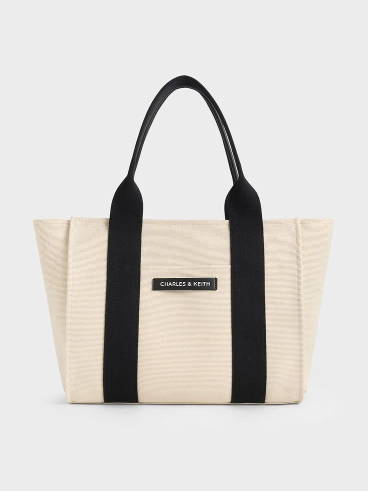 This product is made with at least 20% sustainable materials by weight. CHARLES & KEITH uses recycled, degradable, organic, and water-based materials in our eco-conscious collection.If you are looking for a large tote that is perfect for the summer, this Kay bag checks all the boxes. Made from lightweight canvas with a classic rectangular silhouette, it opens up to a capacious interior that will hold everything you need in a day and more. It is an ideal travel bag that will complement your vacat Eco-friendly Large Capacity Canvas Bag, Summer Eco-friendly Bags With Reinforced Handles, Modern Canvas Bag With Leather Handles For Summer, Summer Canvas Tote Bag For On-the-go, Summer Tote Canvas Bag For On-the-go, Summer On-the-go Canvas Tote Bag, Eco-friendly Summer Bags With Reinforced Handles, Eco-friendly Recyclable Shoulder Bag For On-the-go, Modern Double Handle Canvas Bag For Summer