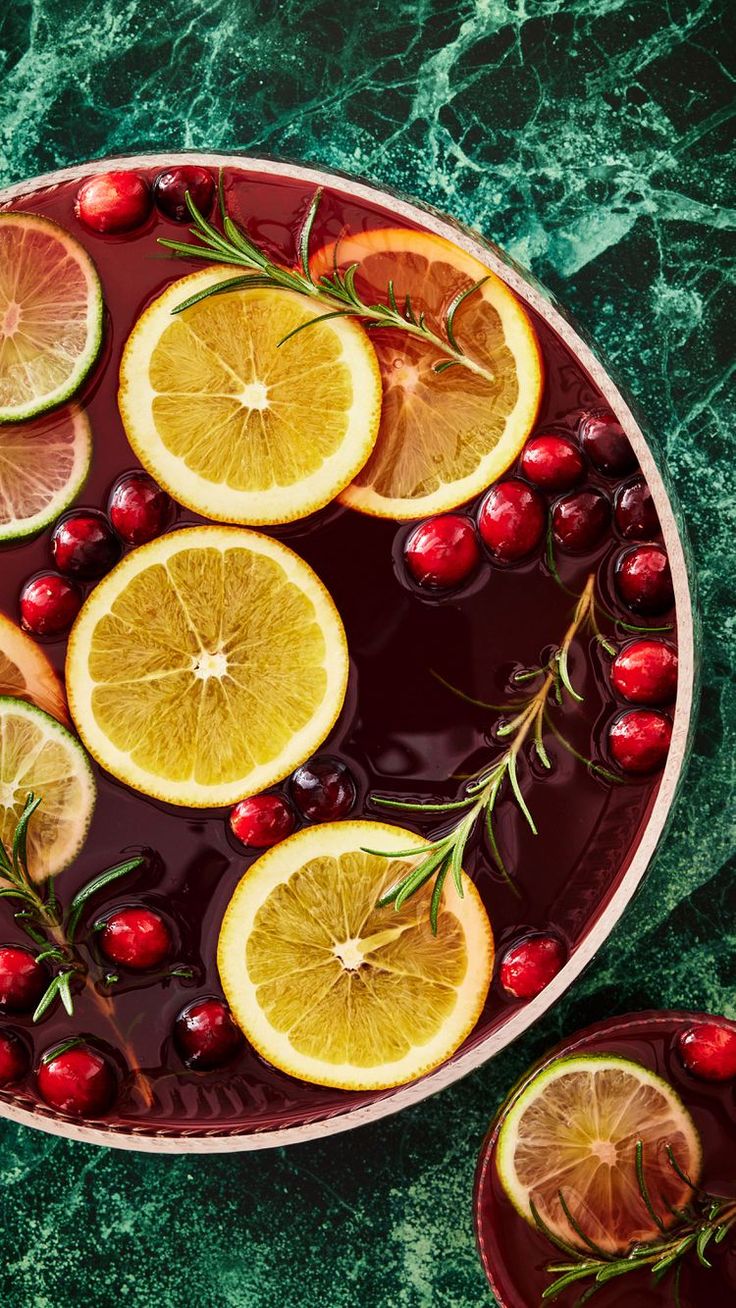 lemons, cranberries and rosemary are arranged in a dish